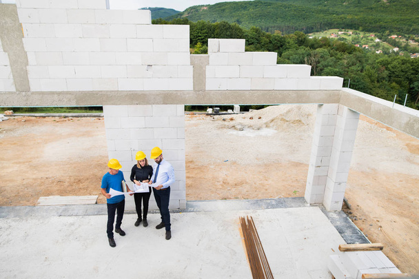 Architects and worker at the construction site. - Foto, imagen