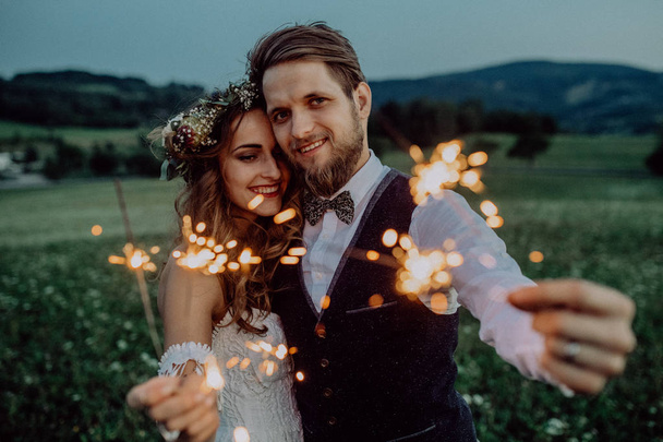 Beautiful bride and groom on a meadow in the evening. - Fotó, kép