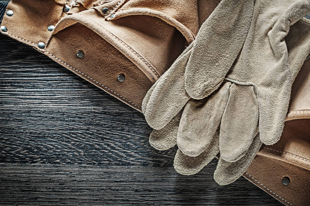 Leather construction belt protective gloves on black board - Φωτογραφία, εικόνα