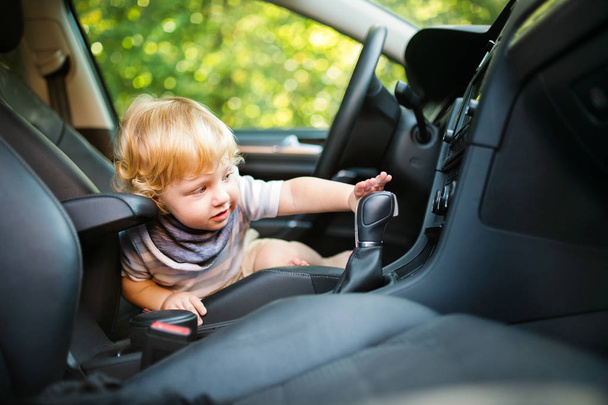 Little boy playing in the car, pretending to drive it. - Foto, Imagem