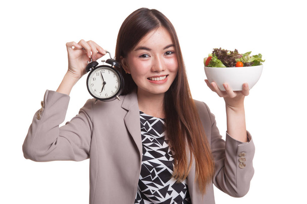 Young Asian woman with clock and salad. - Фото, изображение