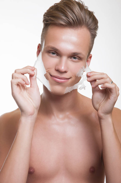 Man removing facial mask from face - Foto, afbeelding
