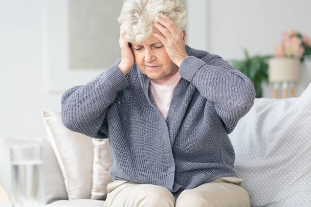 Elderly woman having migraine headache  - 写真・画像
