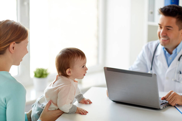femme avec bébé et médecin avec ordinateur portable à la clinique
 - Photo, image
