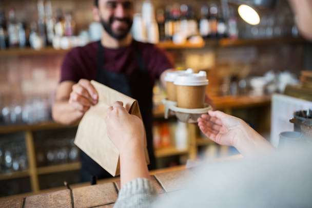 man or bartender serving customer at coffee shop - Фото, изображение
