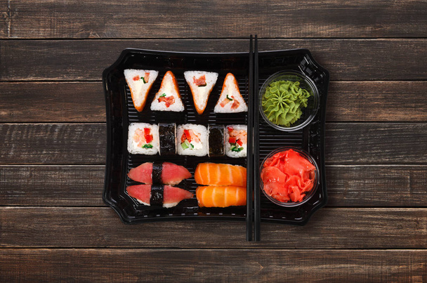 Entrega de comida japonesa. Set de sushi y rollos vista superior en madera
 - Foto, Imagen