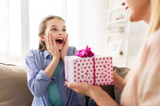 mother giving birthday present to girl at home - 写真・画像