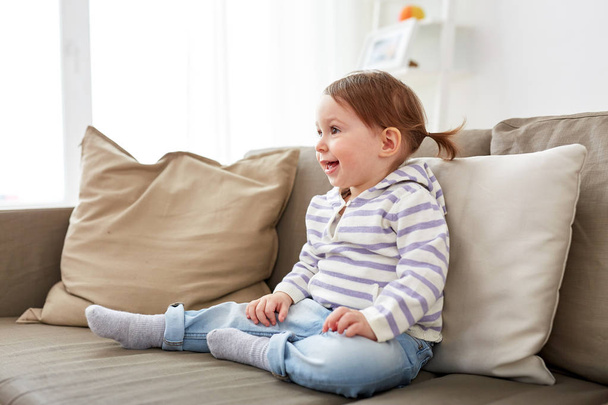 happy smiling baby girl sitting on sofa at home - Fotoğraf, Görsel