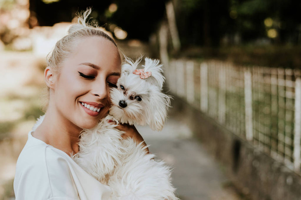 Pretty woman holding maltese dog. - Fotoğraf, Görsel