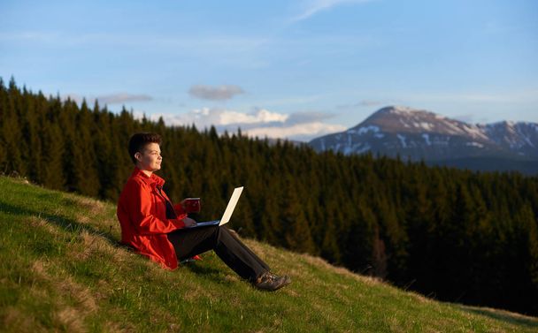 Young woman using laptop outdoors - Photo, Image