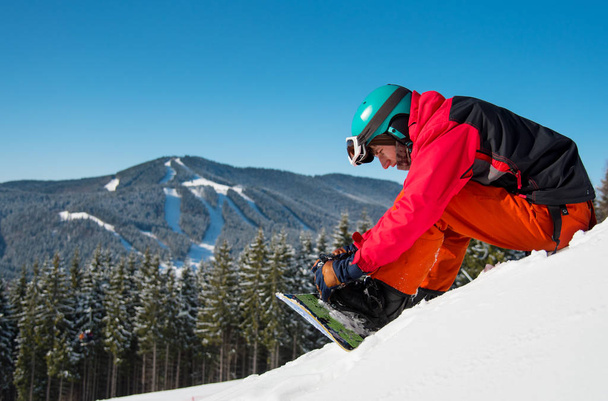 snowboarder sitting on the snowy slope - Foto, imagen