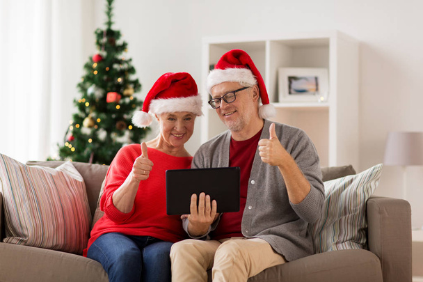 feliz pareja de ancianos con la tableta de PC en Navidad
 - Foto, imagen