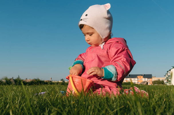 small child playing sitting on a lawn in autumn. - Фото, зображення