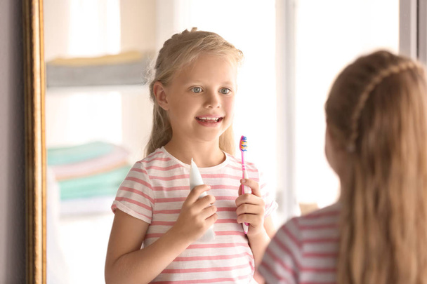 Cute little girl with toothbrush and paste at home. Cleaning teeth concept - Photo, Image