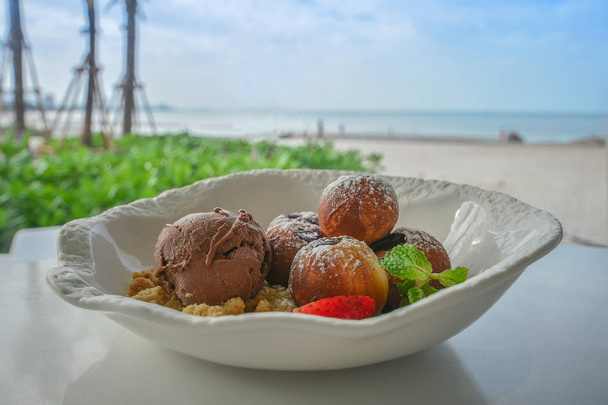 Dodut with Ice cream and Strawberry in Cafe with sea view - Fotó, kép