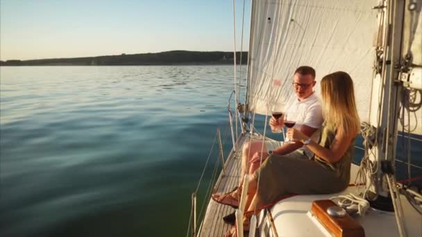 Férfi és nő is bort iszik fedélzetén egy jachton nyáron. - Felvétel, videó
