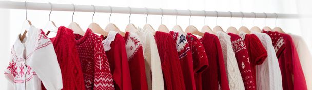 Clothes rack with red Christmas knit wear - Photo, Image