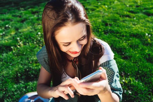 Texting woman,surprised,smiling.grass summer background - Photo, image