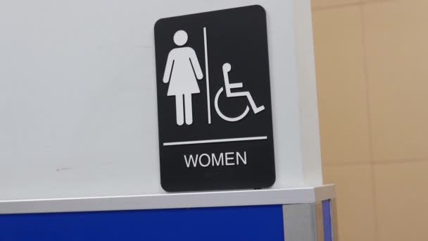 Κίνηση των γυναικών και απενεργοποίηση λογότυπο τουαλέτας στον τοίχο  - Πλάνα, βίντεο