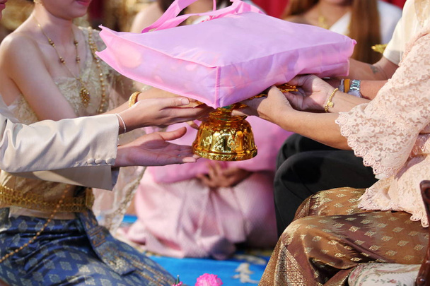 Китайская свадебная чайная церемония Жених и невеста дарят подарок старшим. Селективная фокусировка и мелкая глубина резкости
. - Фото, изображение