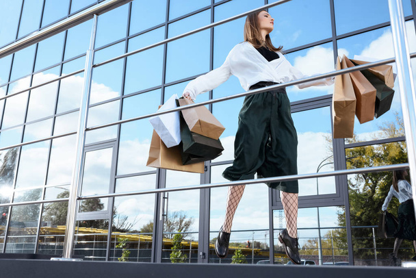 Nainen hyppää ostoskassien kanssa
  - Valokuva, kuva