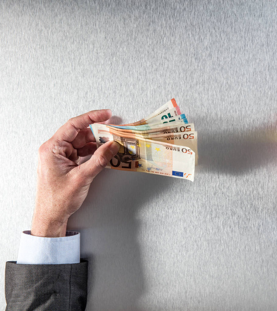 hand of businessman holding euro bank notes for corporate money - 写真・画像