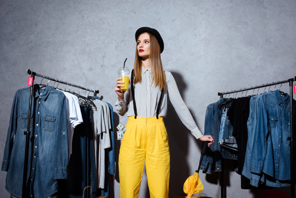 girl in boutique with clothes around - Photo, Image