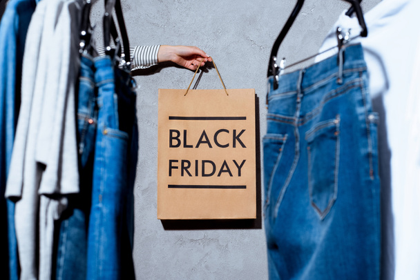 hand with shopping bag on black friday - 写真・画像