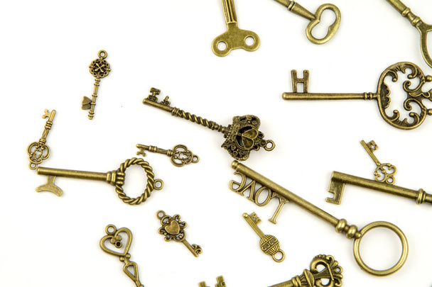 Díszítő középkori vintage keys a bonyolult fleur-de-lis elemek, viktoriánus levél tekercsek és szív alakú kavarog kovácsolás, áll. antik arany ajtó kulcs elszigetelt fehér background - Fotó, kép