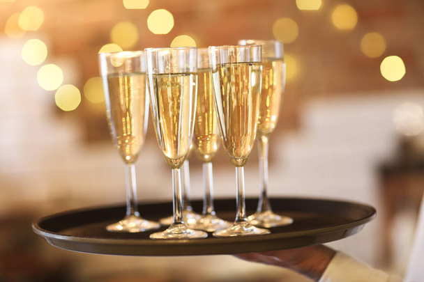 Champagneglazen op dienblad in fel licht - Foto, afbeelding