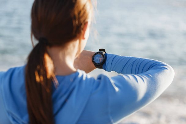 Runner woman with heart rate monitor running on beach - Фото, зображення
