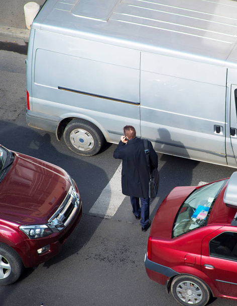 Businessman crossing the road in traffic jam - Photo, Image