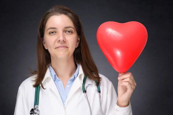 Médico segurando um balão em forma de coração
 - Foto, Imagem
