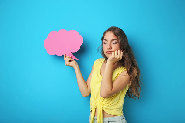Young woman with speech bubble on blue background - Φωτογραφία, εικόνα