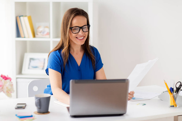 happy woman with laptop working at home or office - Photo, image