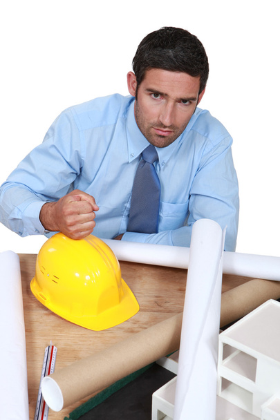 Architect with his fist on a hard hat - Photo, Image
