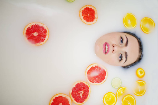 Sexy brunette girl at the bathroom with milk and fruits. Youth b - 写真・画像