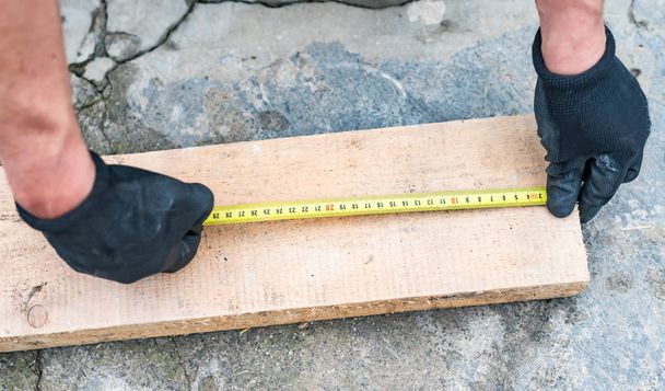 The process of measuring the length of a wooden beam  - Photo, Image