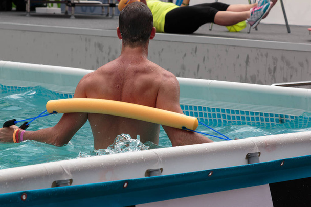 Nuori mies tekee veden aerobic Fitness uima-altaassa L
 - Valokuva, kuva
