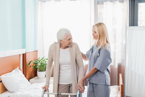 enfermeiro e paciente idoso com andador
 - Foto, Imagem