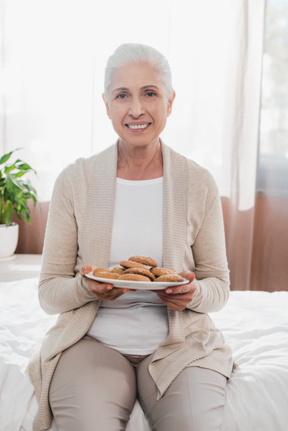 senior woman with cookies in hospital - Фото, изображение