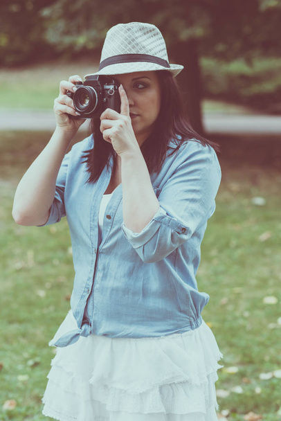 Portrait of pretty young woman using a camera - Foto, imagen