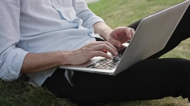 młody człowiek za pomocą laptopa na zewnątrz - Materiał filmowy, wideo