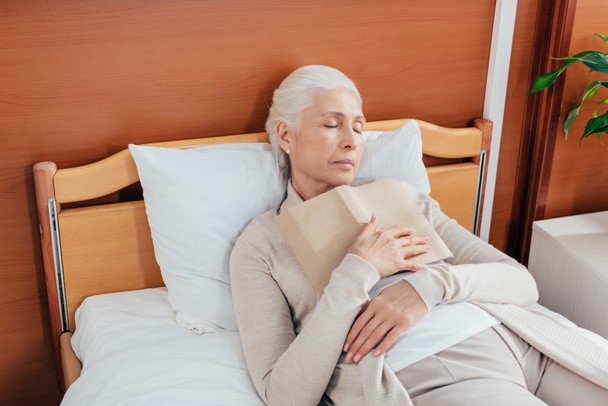 senior woman with book in hospital - Фото, изображение