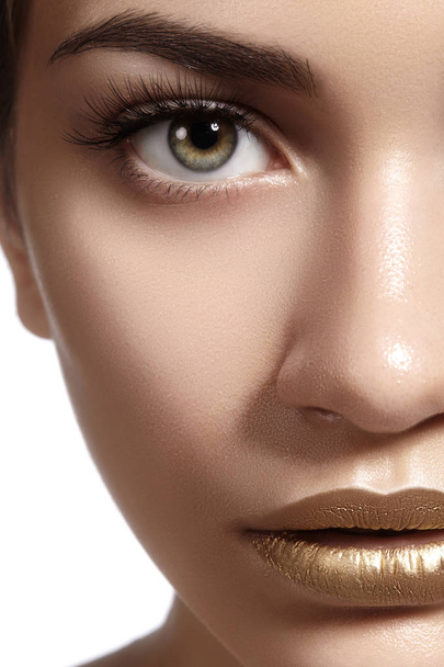Closeup portrait with of Beautiful Woman Face. Gold fashion lip Makeup. Make-up and Cosmetic. Beauty style - Valokuva, kuva