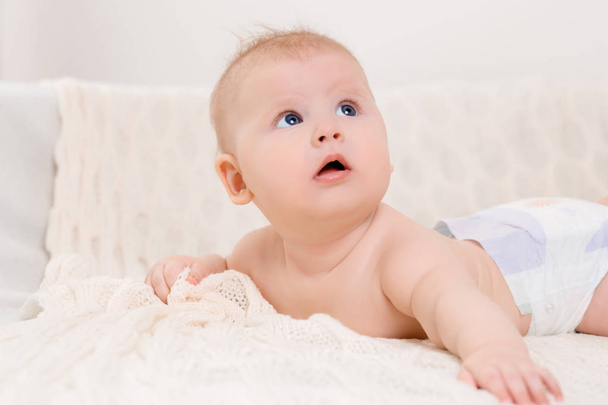 Boldog baba feküdt egy fehér kockás a hálószobában - Fotó, kép