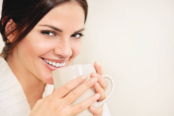 Mladá žena s dlouhými vlasy a hnědé oči pití kávy nebo čaje - Fotografie, Obrázek