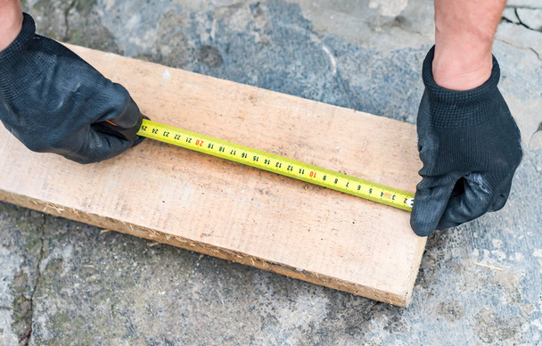 The process of measuring the length of a wooden beam  - Photo, Image