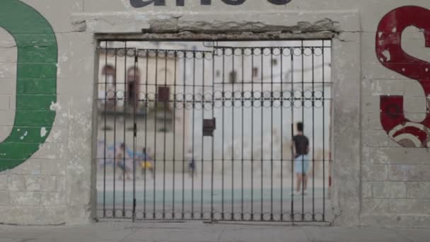 Les enfants jouent au football dans une aire de jeux, tiré à travers la porte
 - Séquence, vidéo