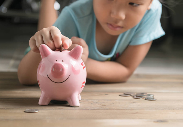 hand girl put coin to piggy bank, saving money  - Photo, Image